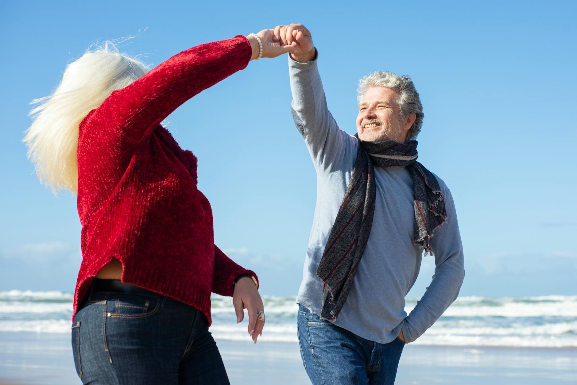 couple holding hands while walking on the beach